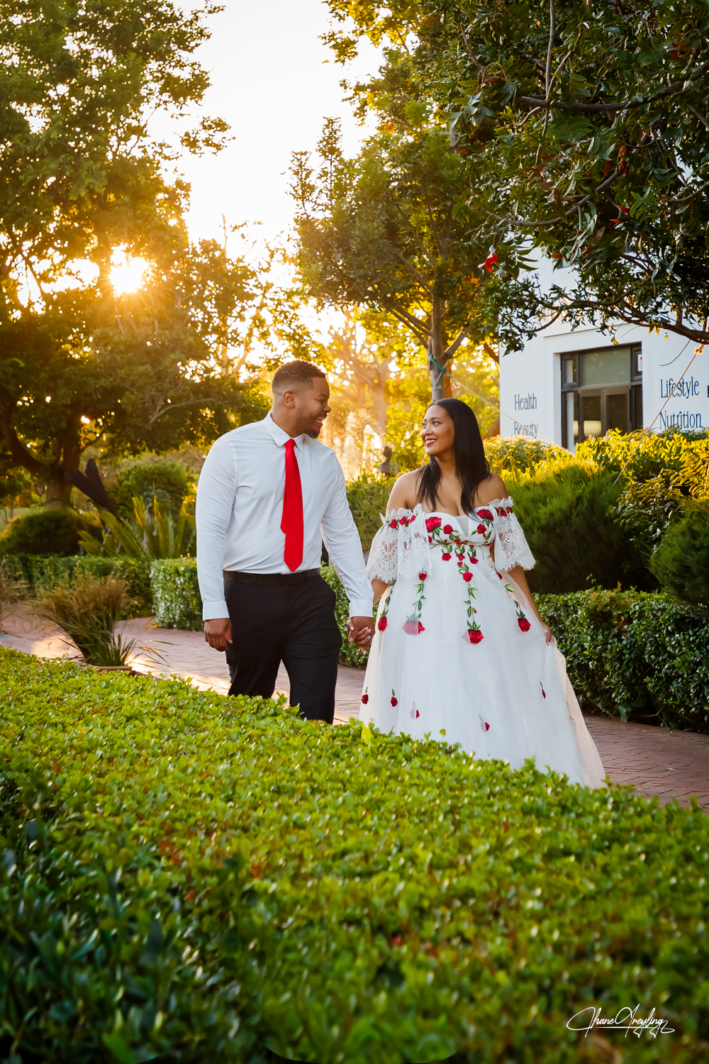 Couple in garden at golden hour, bride in a long sleeve wedding dress, South Africa.